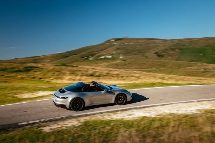 Porsche 911 Targa 4 GTS cruising through a hilly landscape