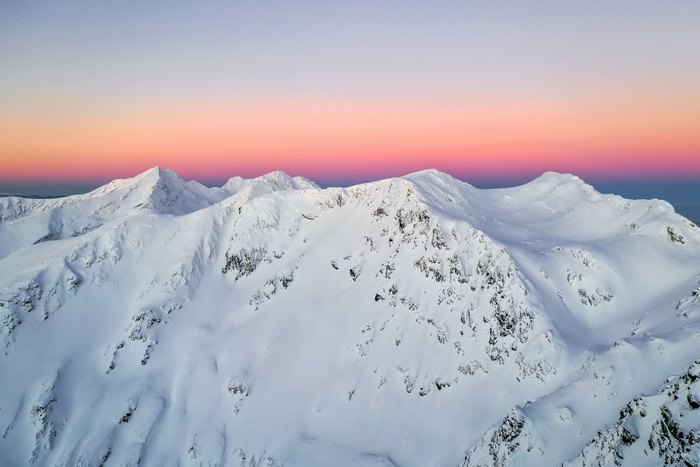 Vibrant sunset over snow-capped Făgăraș Mountains