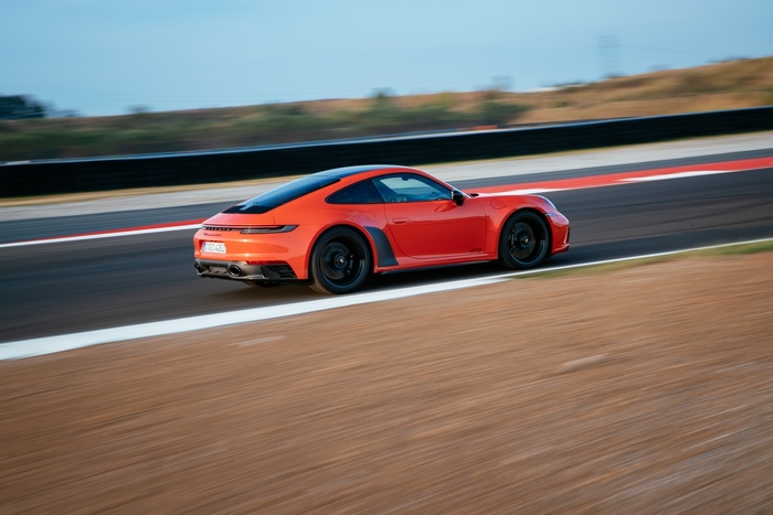 Orange Porsche 911 Carrera GTS speeding on track