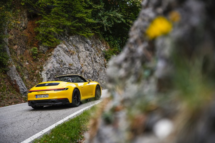 Yellow Porsche 911 Carrera GTS Cabriolet on mountain road
