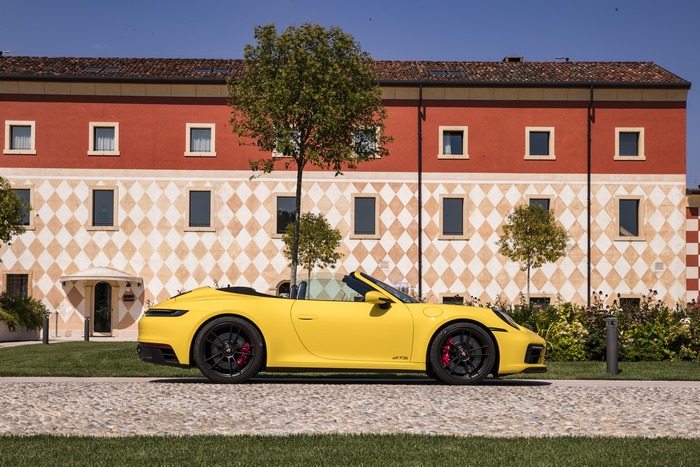 Yellow Porsche 911 GTS Cabriolet parked by a building