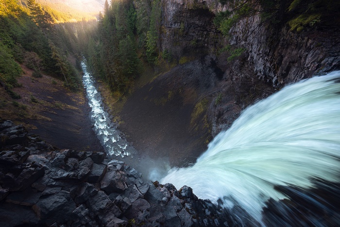 Powerful Waterfall Plunging into a Deep Forested Canyon