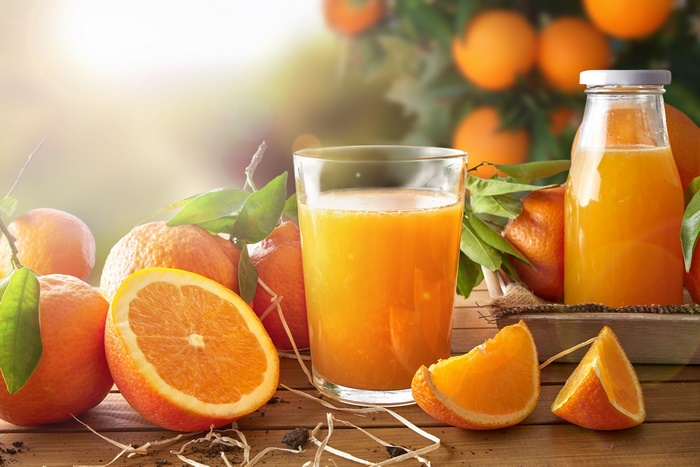 Fresh Orange Juice and Oranges on Wooden Table