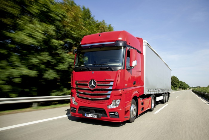 Red Mercedes-Benz Actros Truck Driving on Road