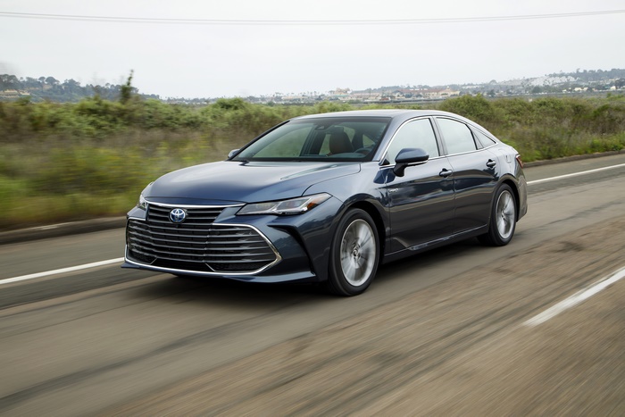 Blue Toyota Avalon driving on road