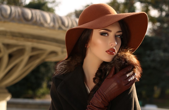 Elegant woman in brown hat, lipstick, and leather gloves
