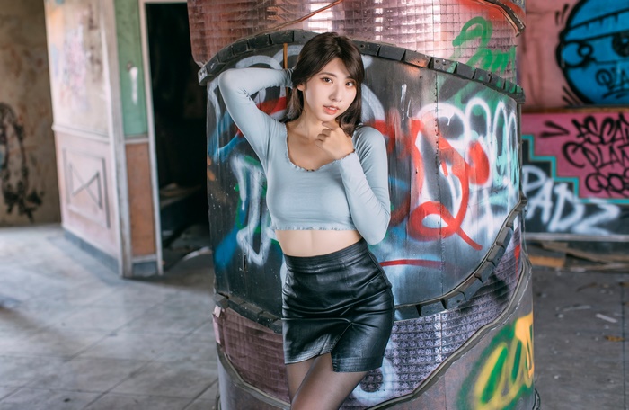 Asian Brunette Model in Skirt Posing by Graffiti Pillar