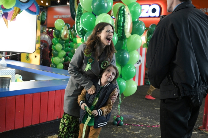 Lyndsy Fonseca laughing with child at green balloon event