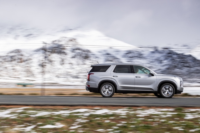 Hyundai Palisade SUV driving through snowy mountains