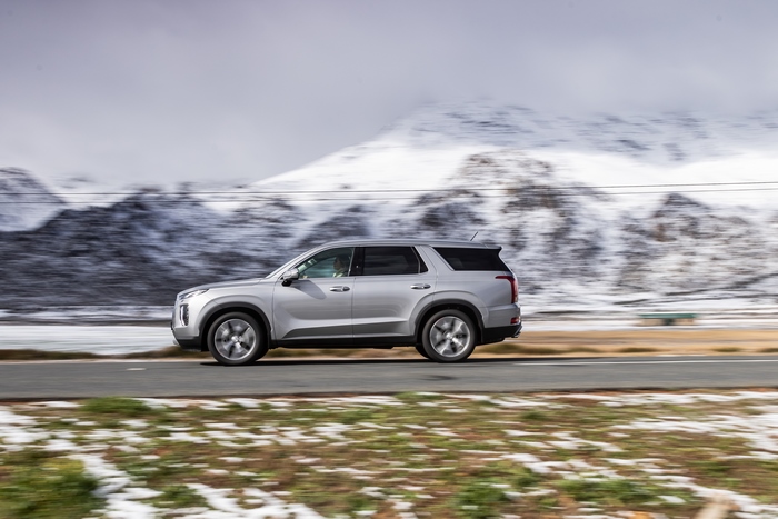 Hyundai Palisade SUV driving through snowy mountains