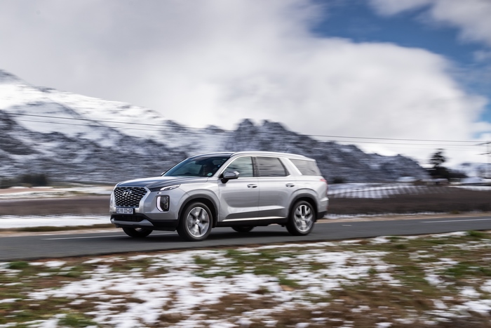 Hyundai Palisade SUV driving through snowy mountains
