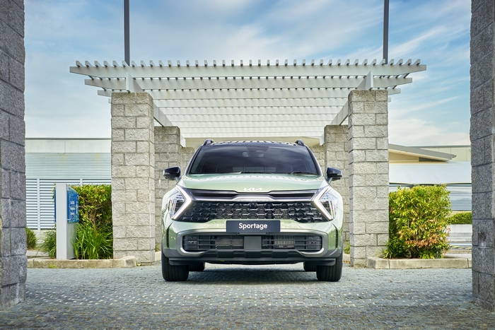 Green Kia Sportage SUV parked under a pergola