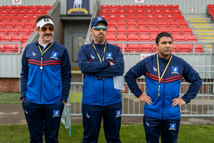 Ted Lasso and coaches on the pitch