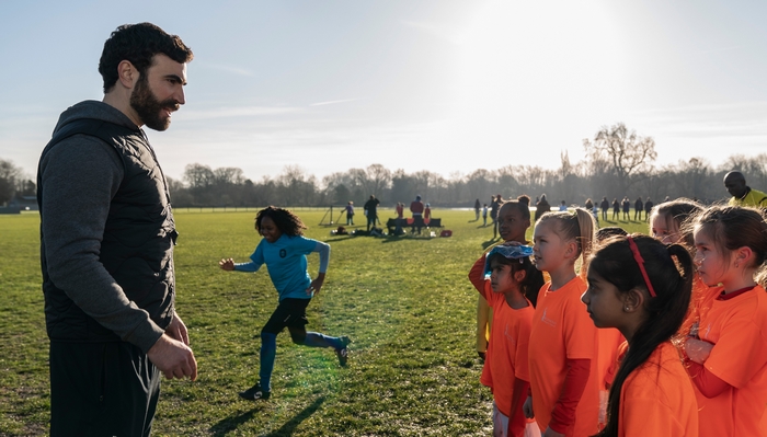 Brett Goldstein coaching kids on a sunny soccer field