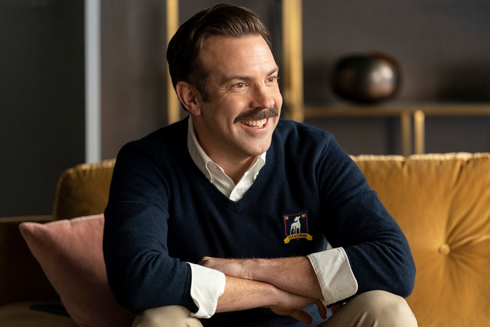 Jason Sudeikis smiling in a navy blue sweater