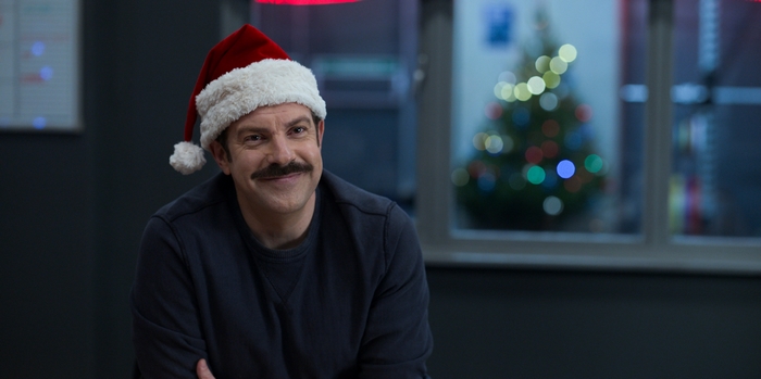 Ted Lasso in Santa hat smiling at Christmas