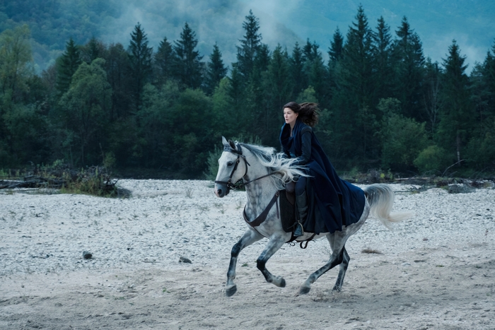 Rosamund Pike riding a white horse in The Wheel of Time
