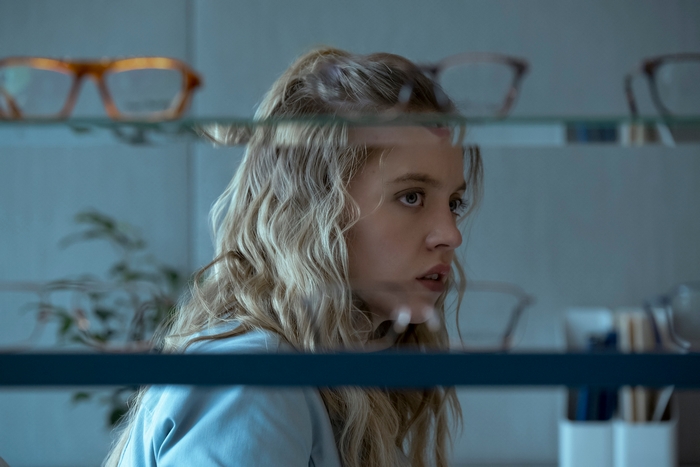Sydney Sweeney looking at glasses