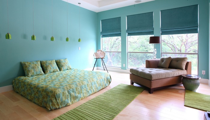 Modern bedroom with teal walls and green accents