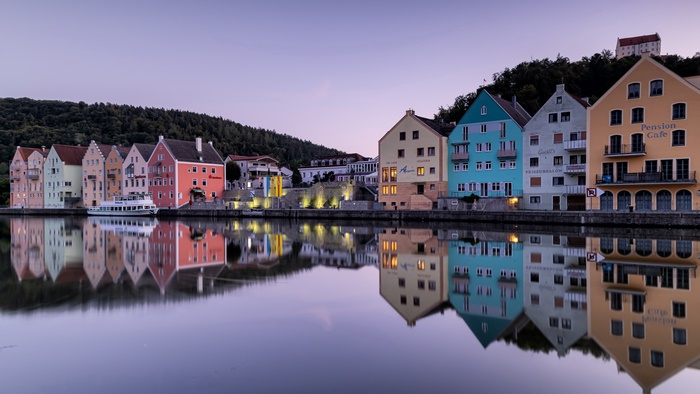 Colorful Riedenburg buildings reflected in water at dusk