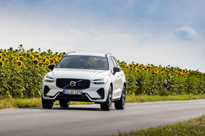 Luxury Volvo XC60 SUV driving through sunflower field