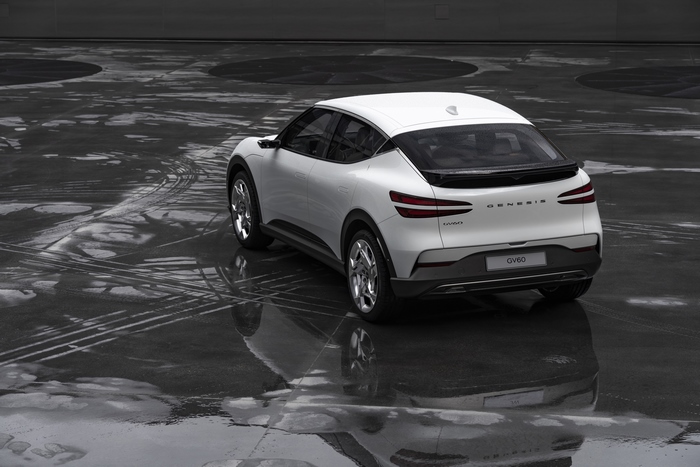 White Genesis GV60 SUV on wet pavement