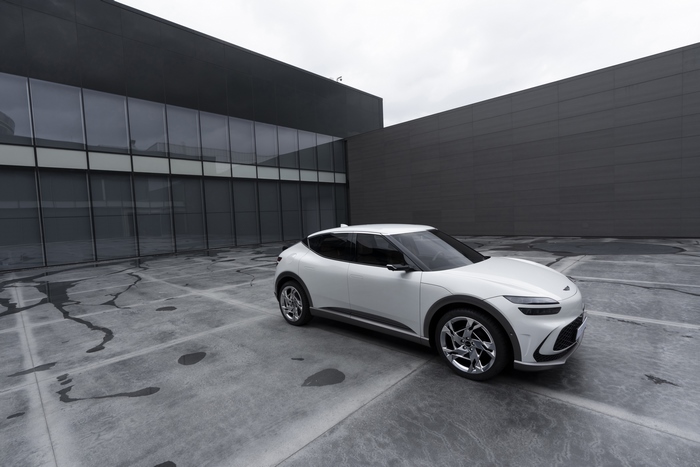 White Genesis GV60 SUV parked outside modern building