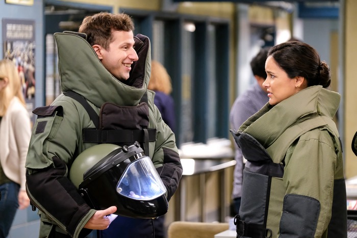 Andy Samberg and Melissa Fumero in bomb suits