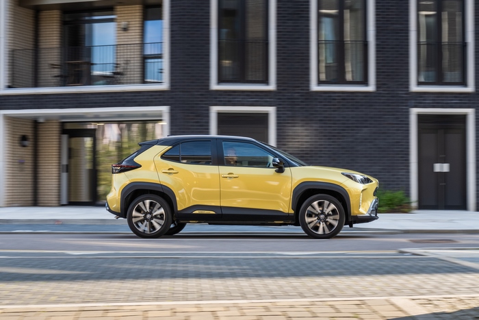 Yellow Toyota Yaris Cross Hybrid SUV on city street