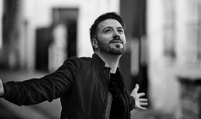 Joyful Danny Gokey with arms open wide