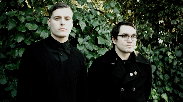 Deafheaven band members portrait against green foliage