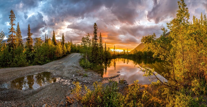 Kola Peninsula sunset over lake and forest road