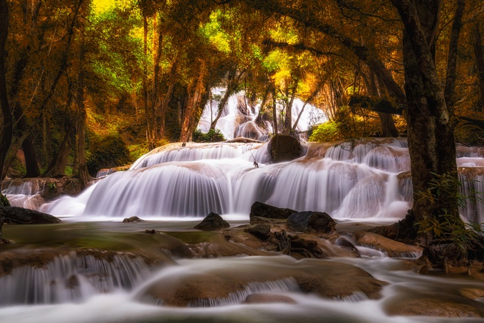 Stunning waterfall cascading through a golden autumn forest