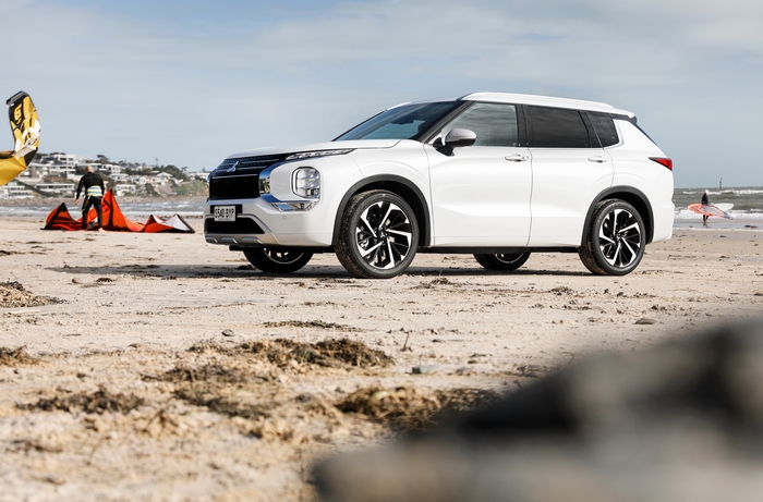Mitsubishi Outlander SUV on beach with kitesurfing