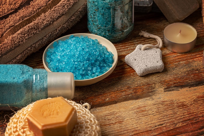Blue bath salts and spa accessories on wooden table