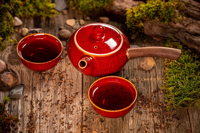 Red Teapot and Tea Cups on Rustic Wood