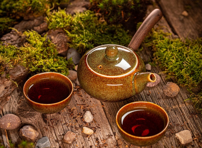 Teapot and Tea Cups on Rustic Wood with Moss