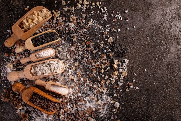 Assortment of gourmet salts in wooden scoops