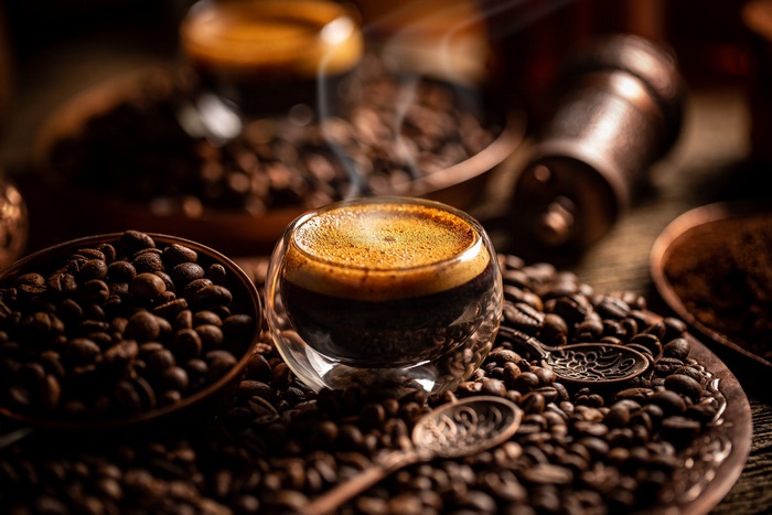 Steaming espresso with roasted coffee beans