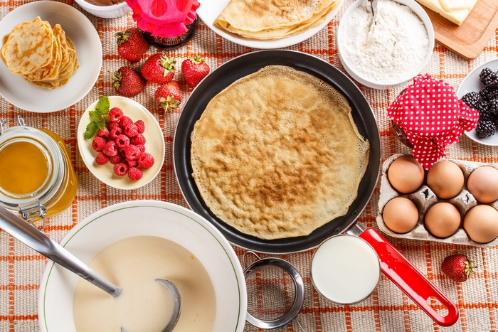 Crêpe ingredients and freshly cooked crepes still life