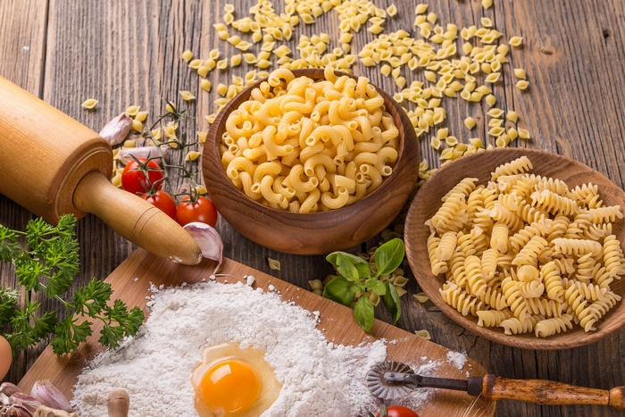 Rustic still life of pasta ingredients and dry pasta