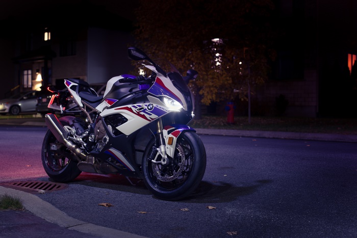BMW S1000RR Motorcycle with Bright Headlights at Night