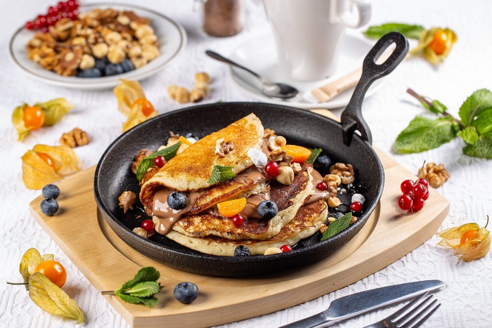 Pancakes with Chocolate, Berries, and Nuts in a Skillet
