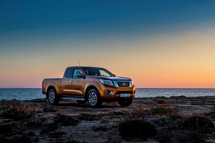 Nissan Navara pickup on rocky shore at sunset