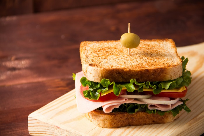 Fresh club sandwich with ham, cheese, and olive