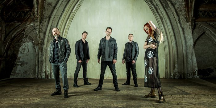 Nemesea music group posing in an old building
