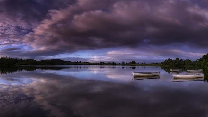 Dramatic Purple Sky Reflected in Lake with Boats