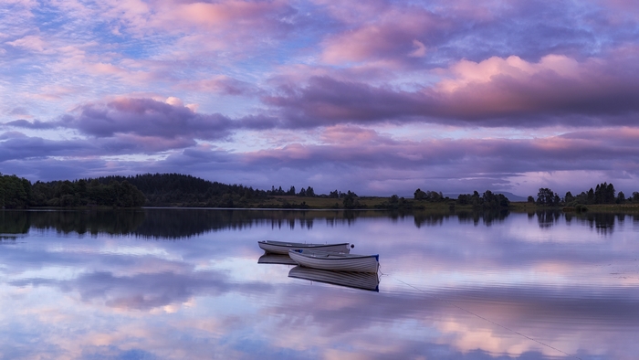 Beautiful Lake Reflection with Purple Clouds and Boats