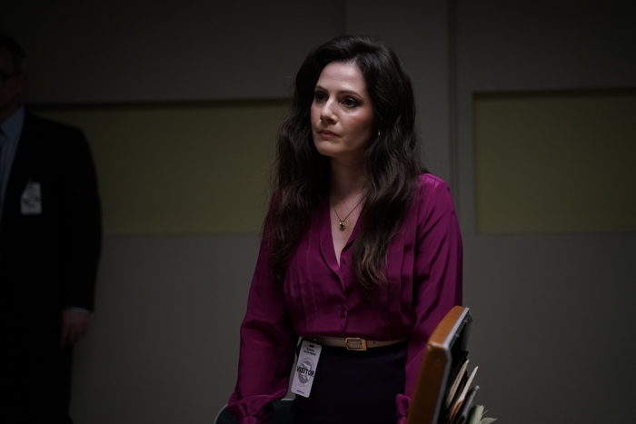 Aleksa Palladino looking serious in purple blouse with visitor badge