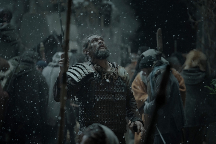 Jason Momoa in armor looking up in the snow